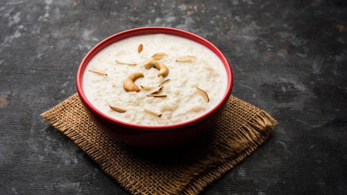 Creamy dessert with nuts in red bowl