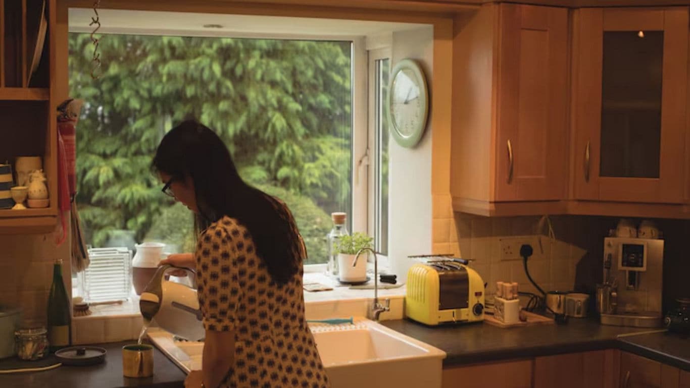 Woman Washing Dishes in Cozy Kitchen Interior