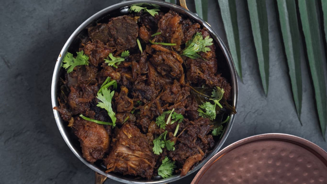 Spiced meat curry garnished with fresh cilantro