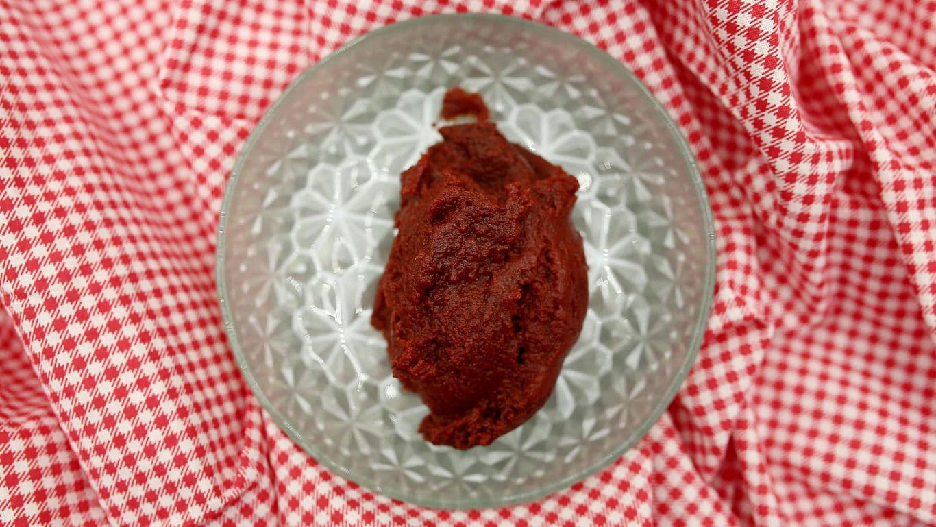 Tomato paste in glass bowl on cloth