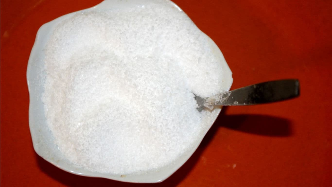 White granulated sugar in bowl with spoon