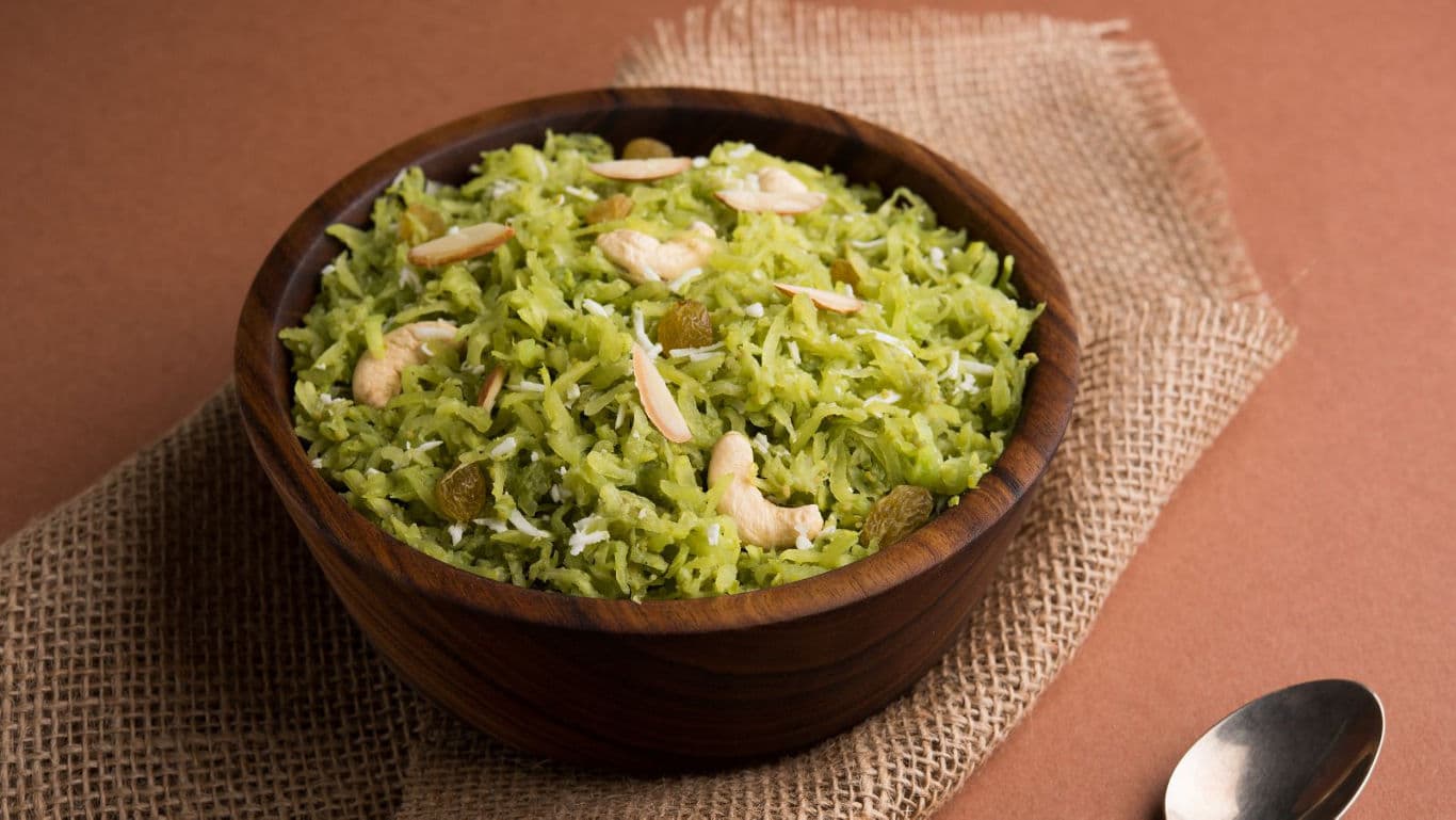 Wooden bowl of green sweet rice with nuts