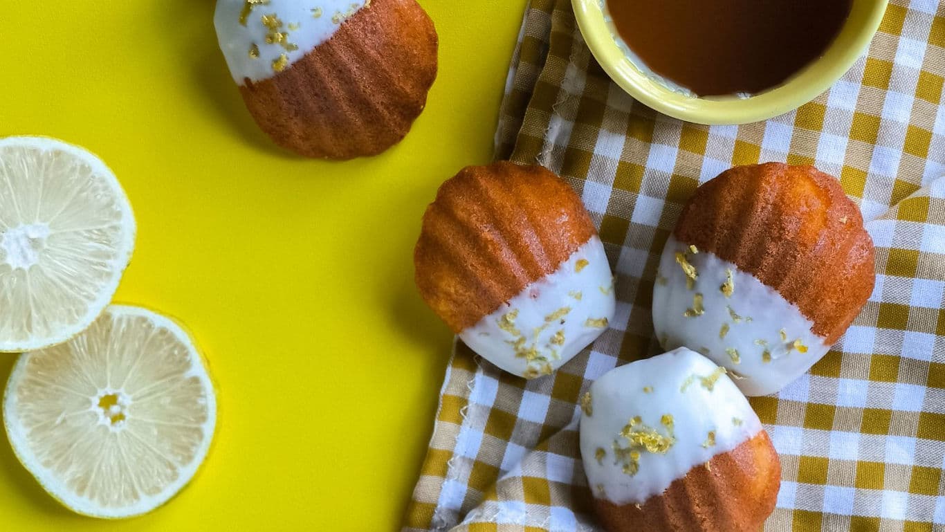 Lemon glazed madeleines on yellow background