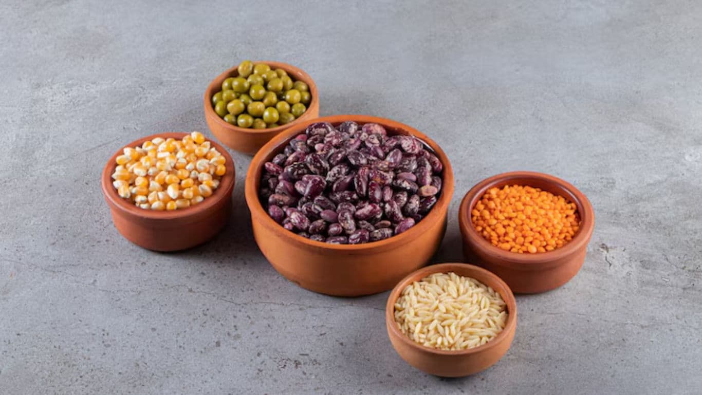 Assorted legumes and grains in clay bowls