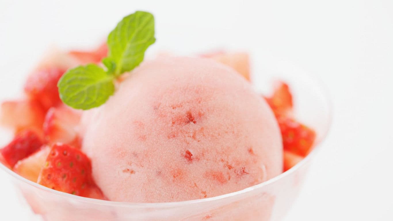 Strawberry sorbet with fresh mint garnish in bowl