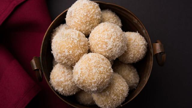 Freshly made coconut laddoos coated with desiccated coconut.