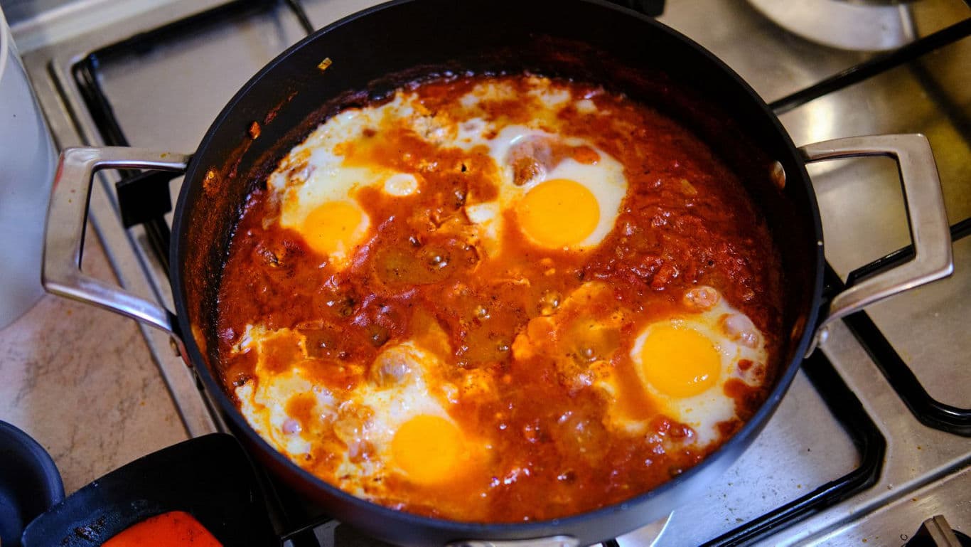 Shakshuka desi-style cooking in a round pan for a quick dinner