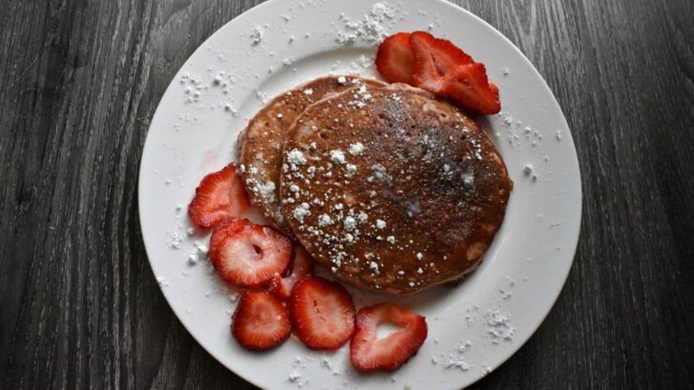 Ragi pancakes with strawberries and powdered sugar.