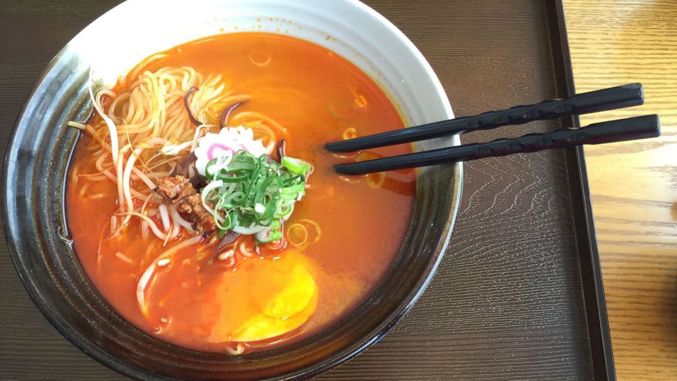 Spicy ramen bowl with chopsticks on tray