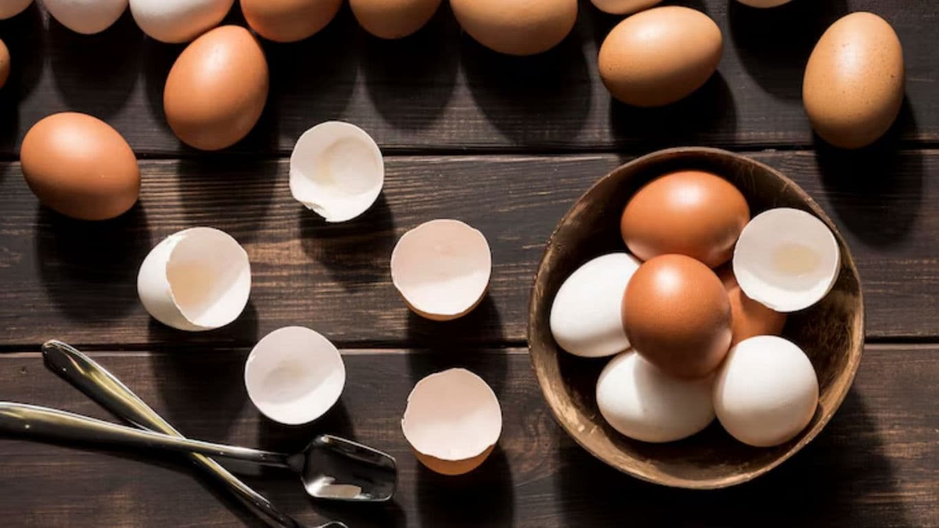 Brown and white eggs with cracked shells on table