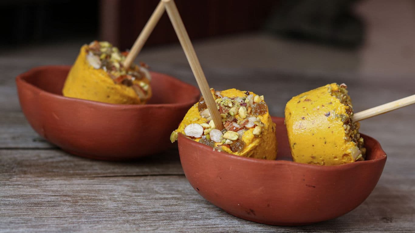 Mango kulfi in bowls.