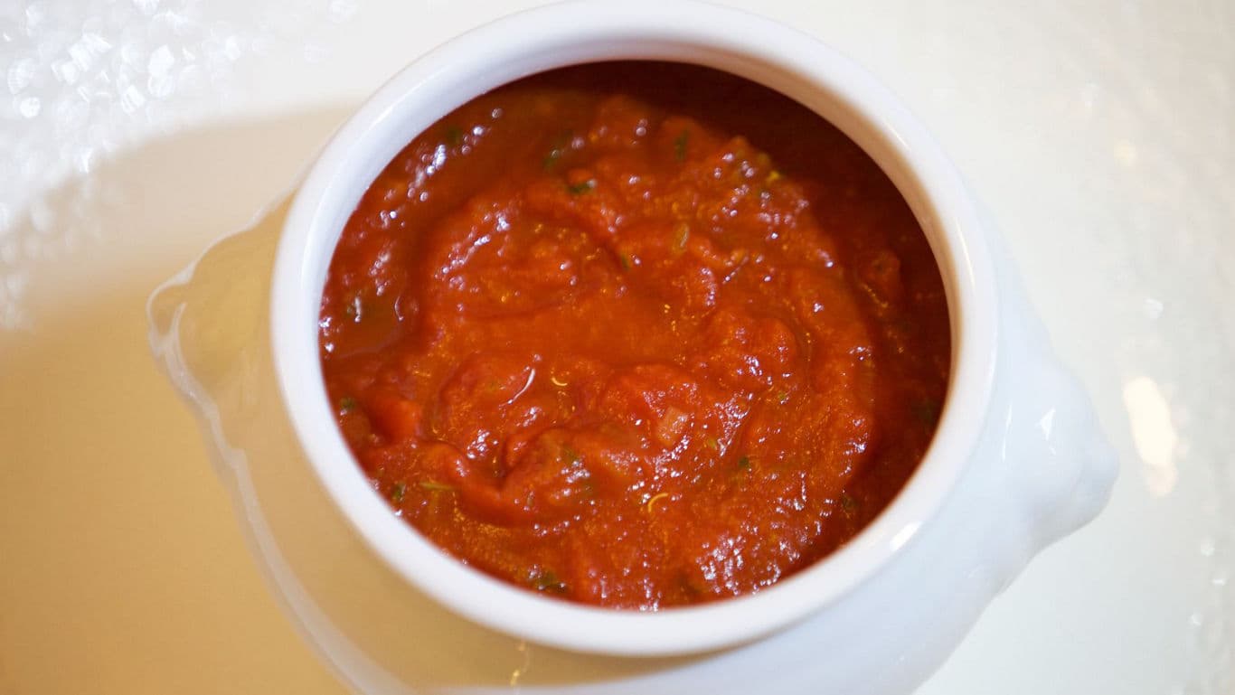 Tomato-based sauce served in white ceramic bowl