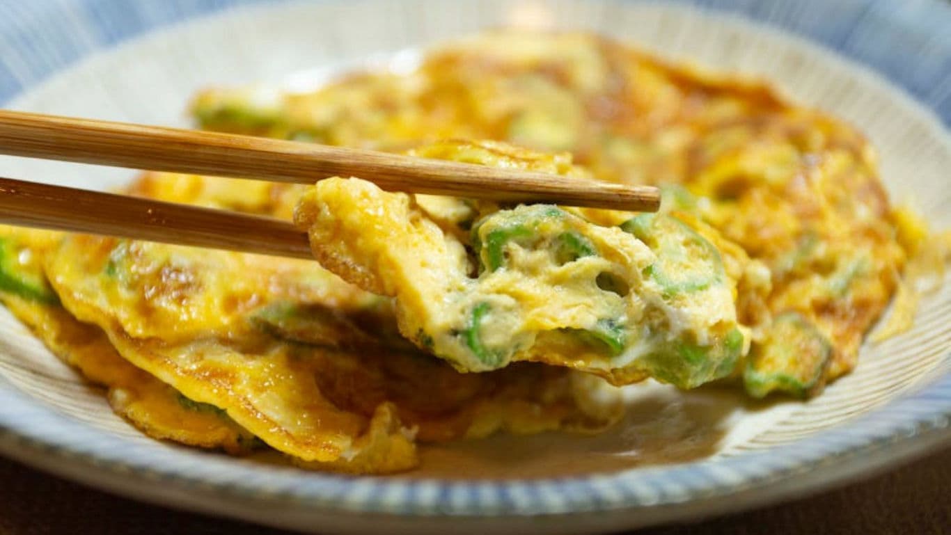 Chopsticks Holding Slice of Vegetable Omelette