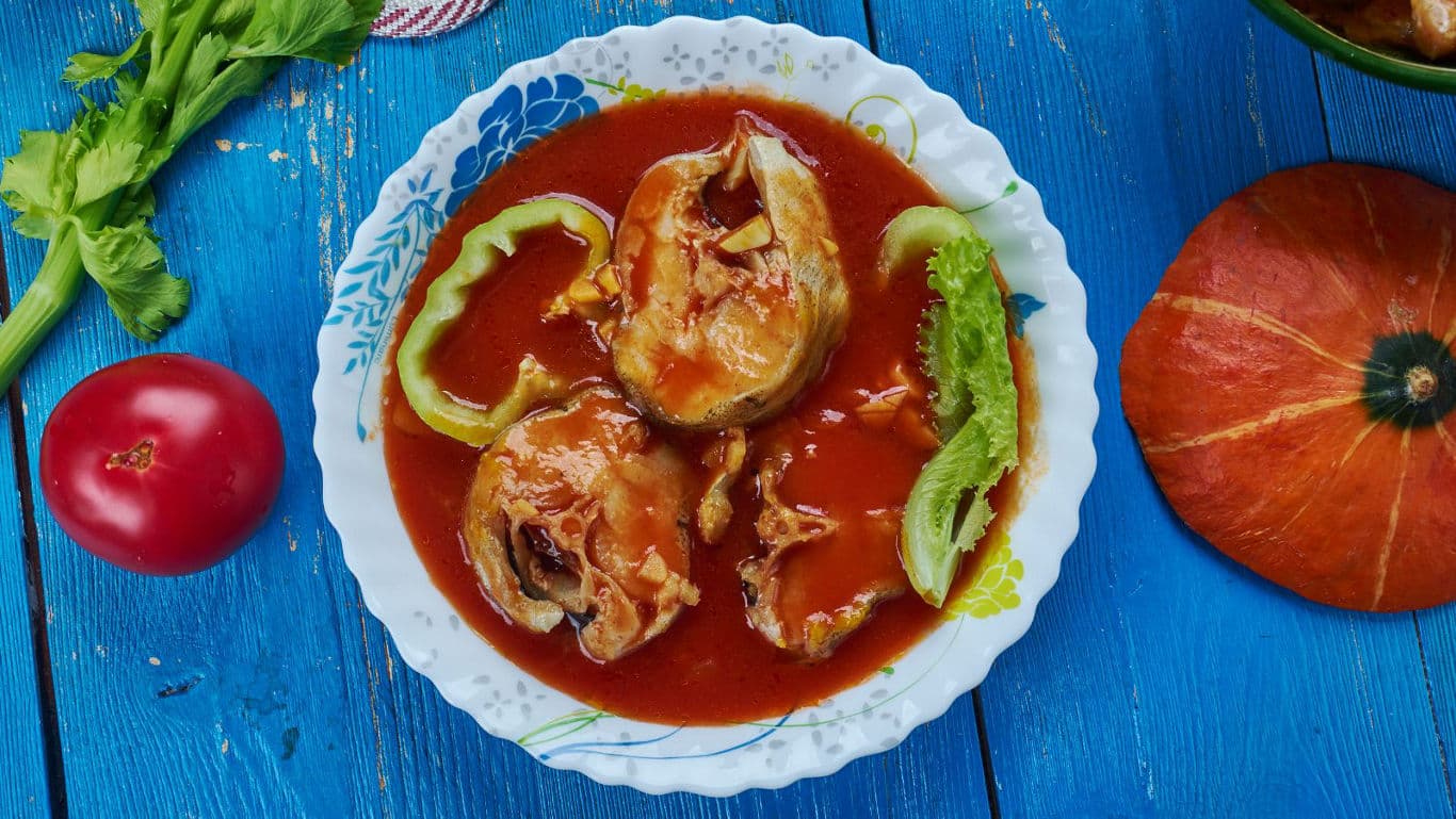 Stuffed peppers in tomato sauce on rustic plate