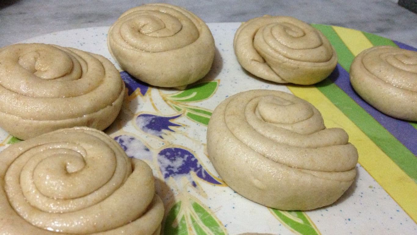 Unbaked spiral bread rolls on tray