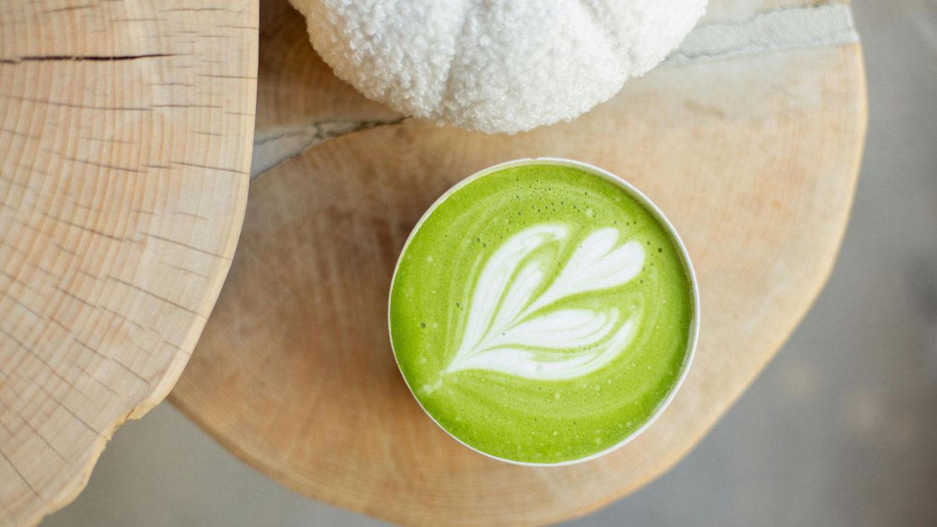 Matcha latte with latte art on wood
