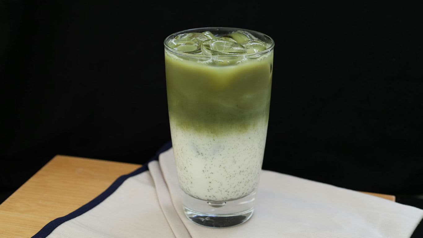 Iced layered matcha latte on napkin