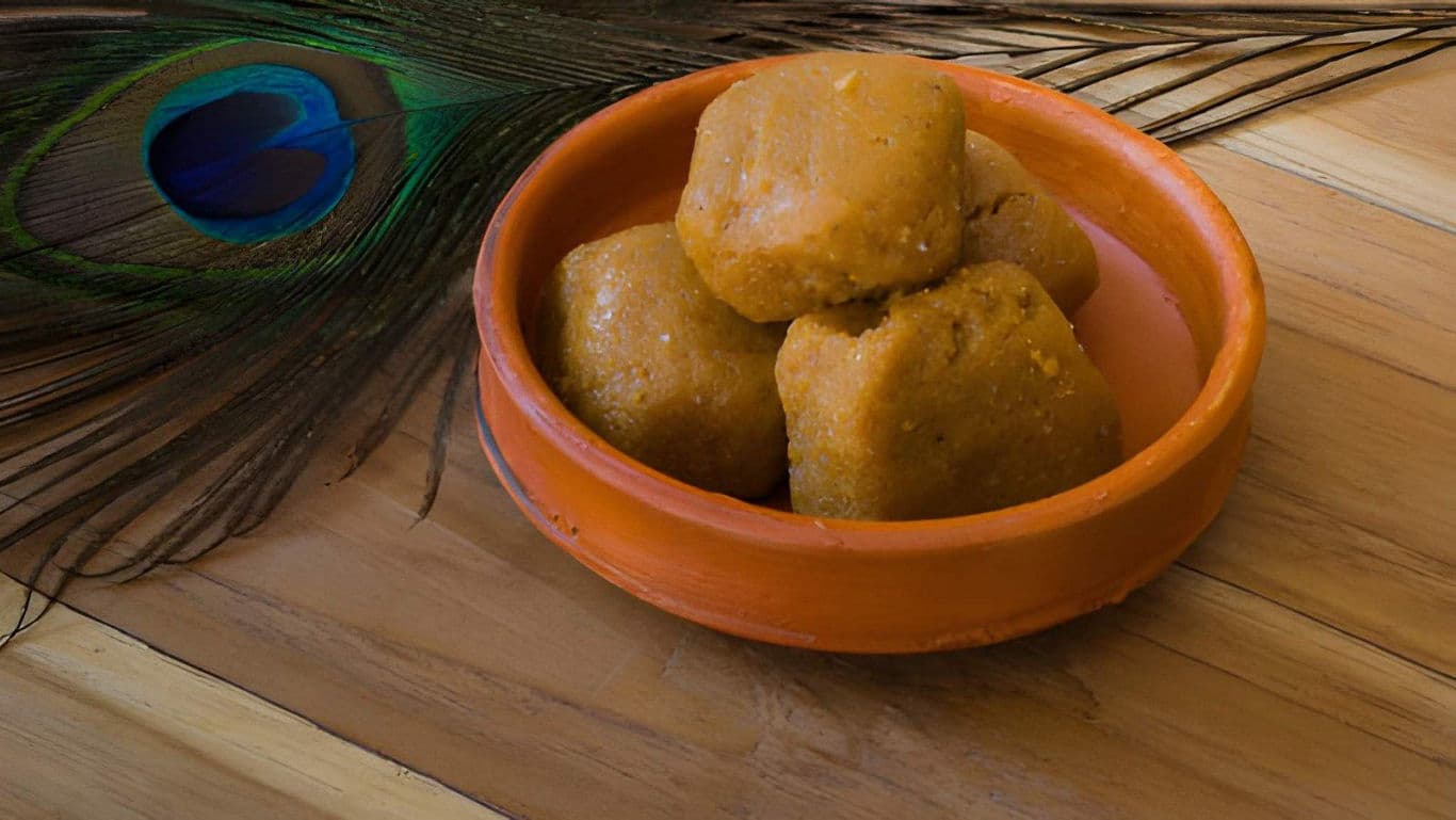 Traditional Indian sweets in clay bowl with peacock feather