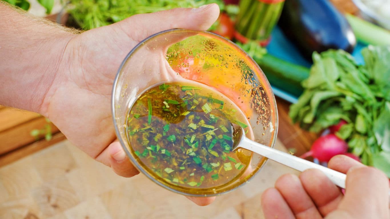 Fresh herb vinaigrette in glass bowl with spoon