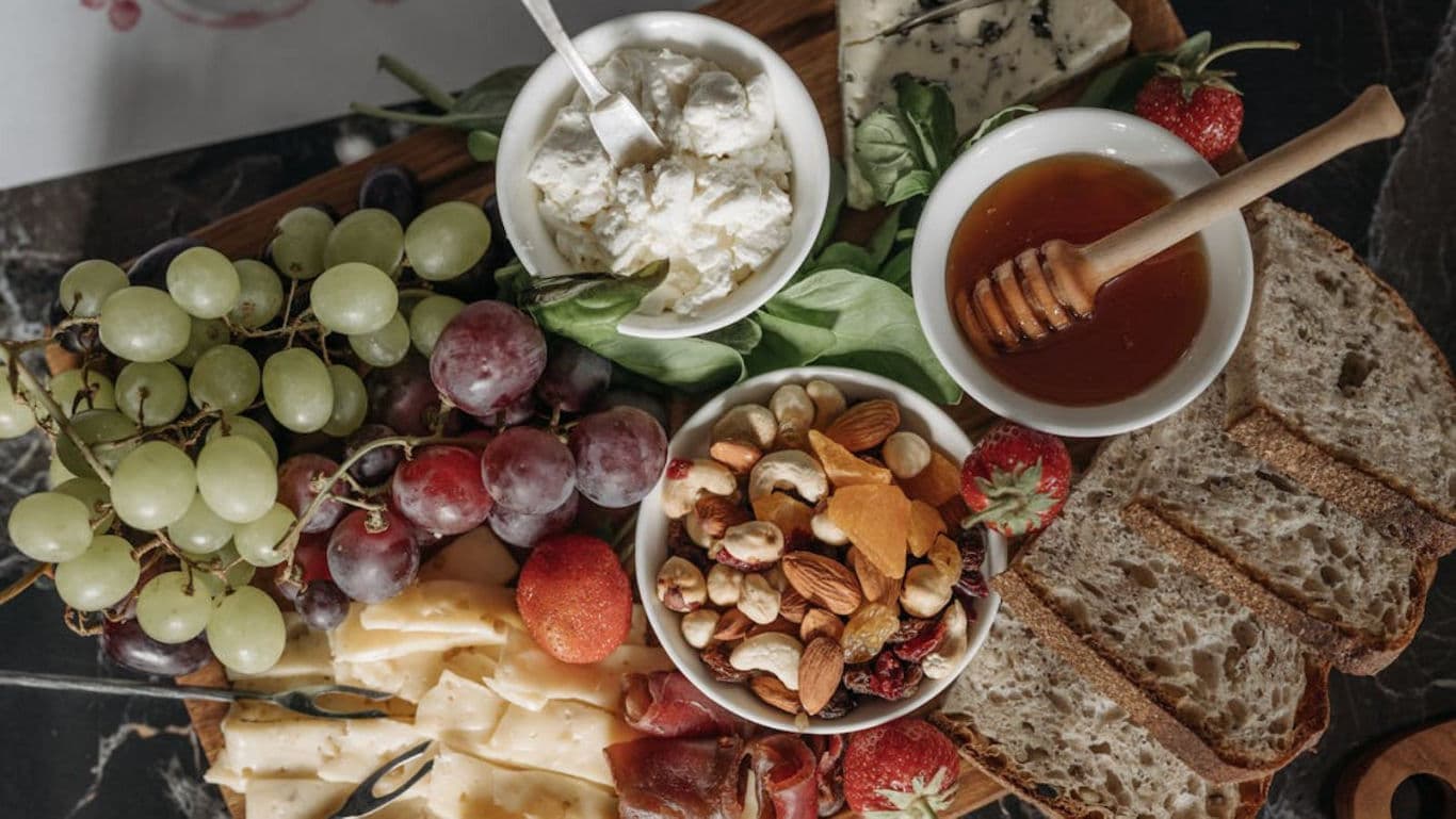 Gourmet cheese board with honey and fresh fruit