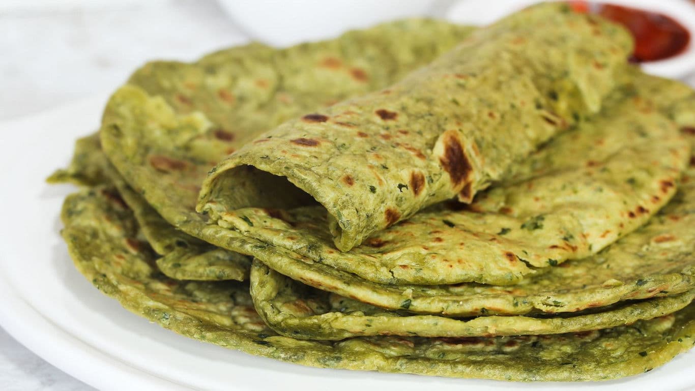 Stack of green Indian flatbreads on white plate