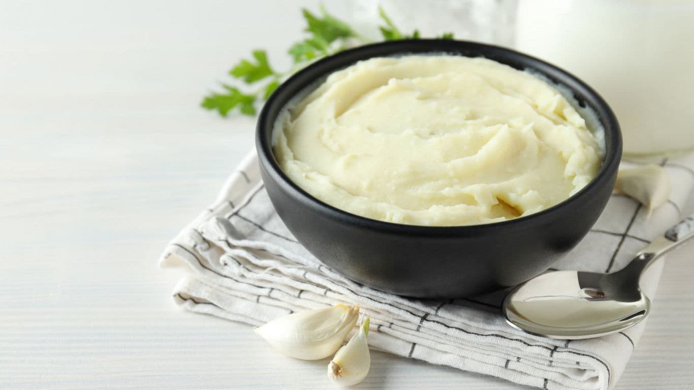 Creamy mashed potatoes in black bowl