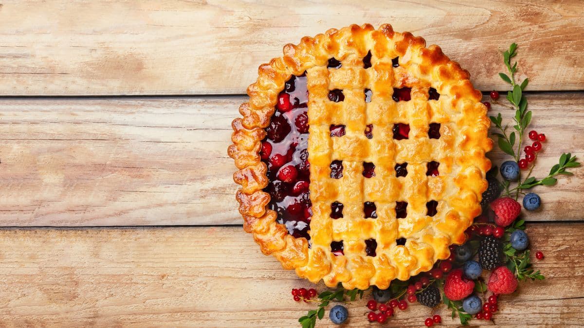 Mixed berry pie with lattice top and berries on the side