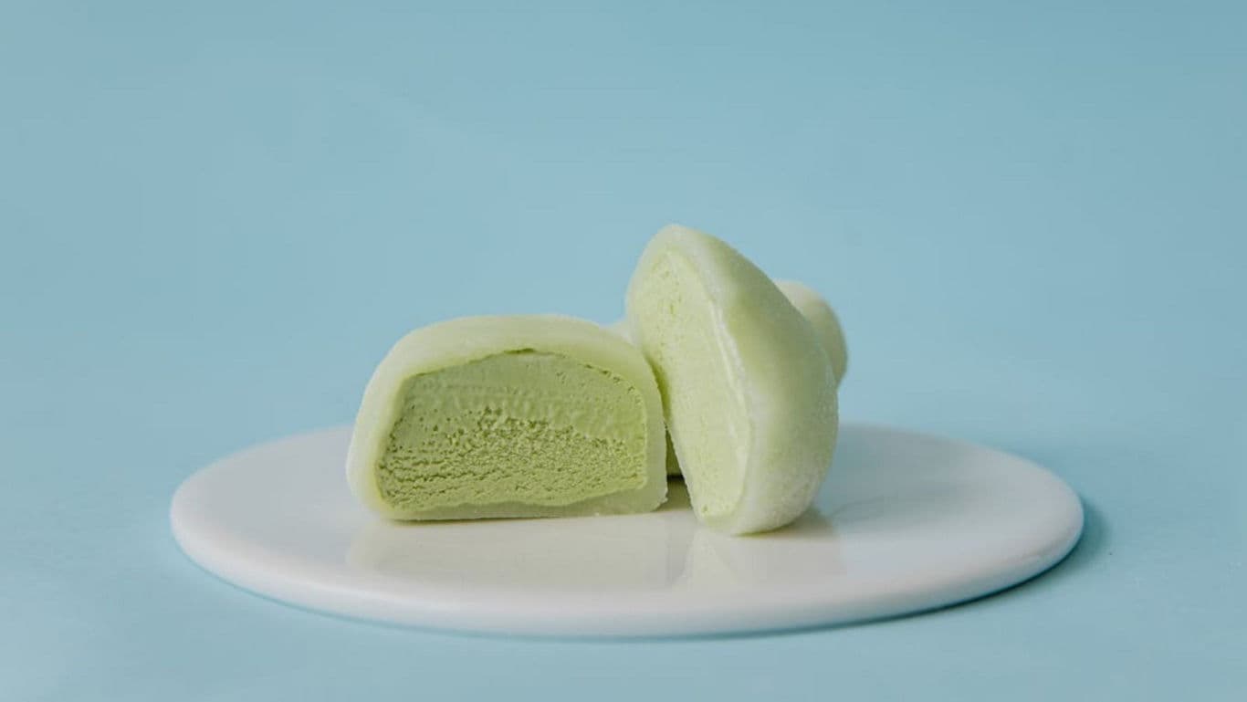 Green mochi ice cream halves on white plate