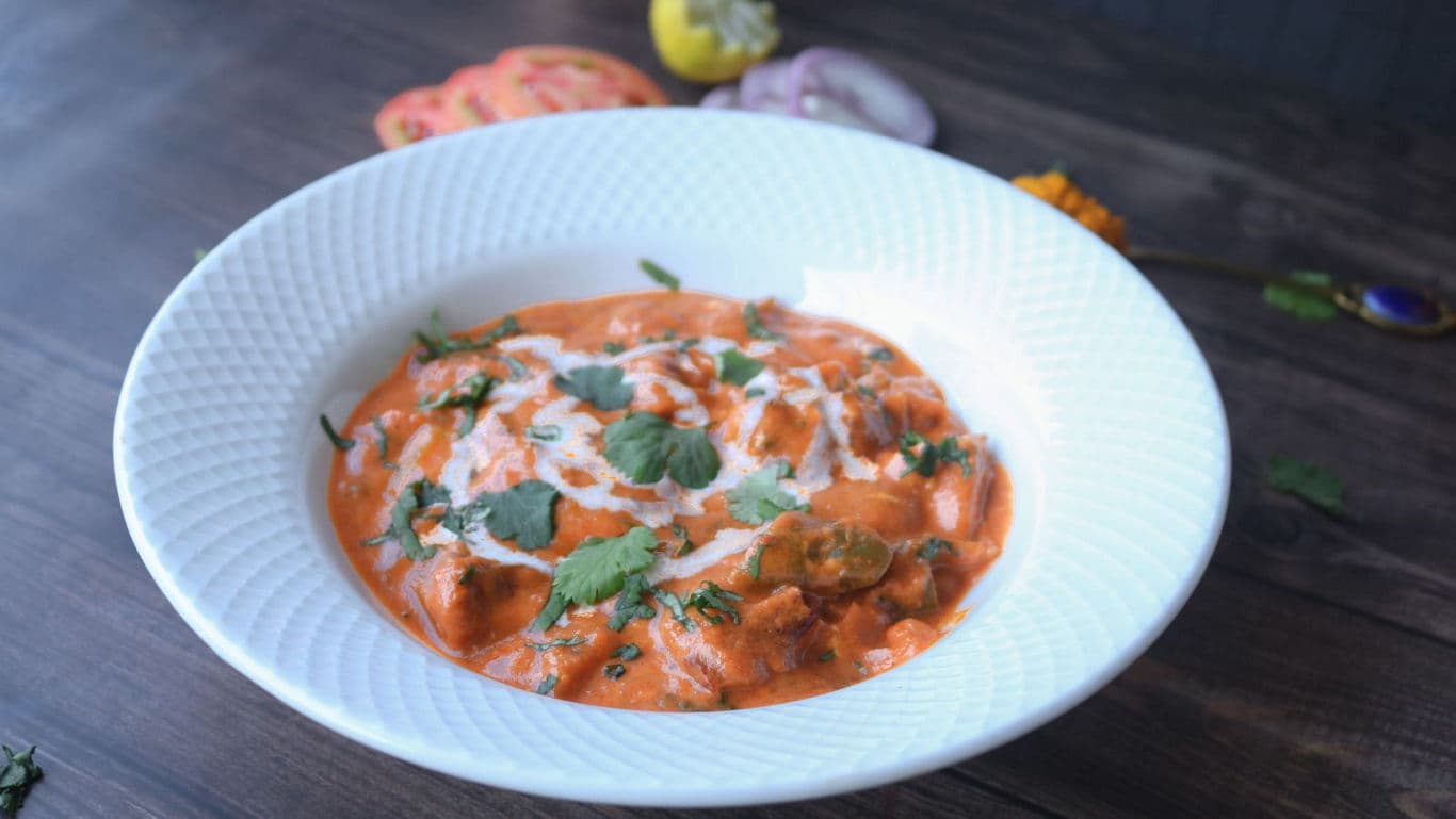 Creamy orange curry served in white bowl