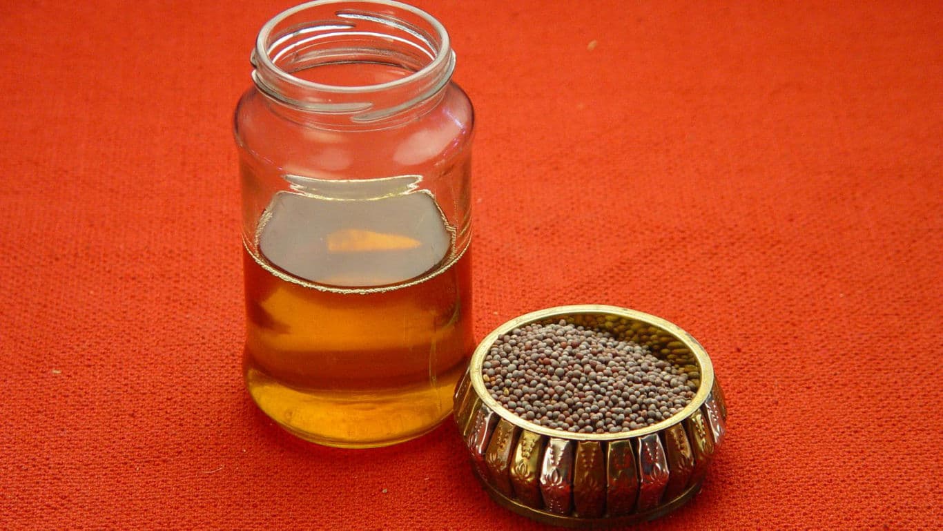 Glass Jar of Mustard Oil and Mustard Seeds