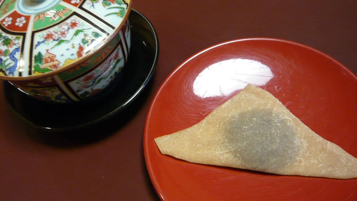 Traditional Japanese sweet on red plate with ornate bowl