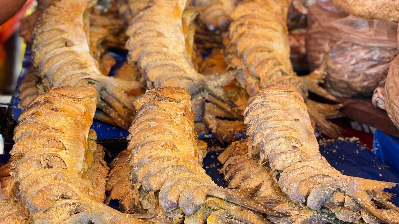 Grilled seasoned fish displayed at market stall