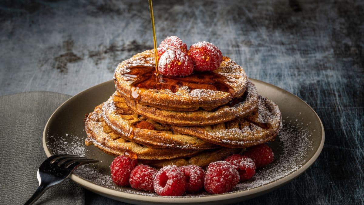Pancake stack with sugar, strawberry, and syrup
