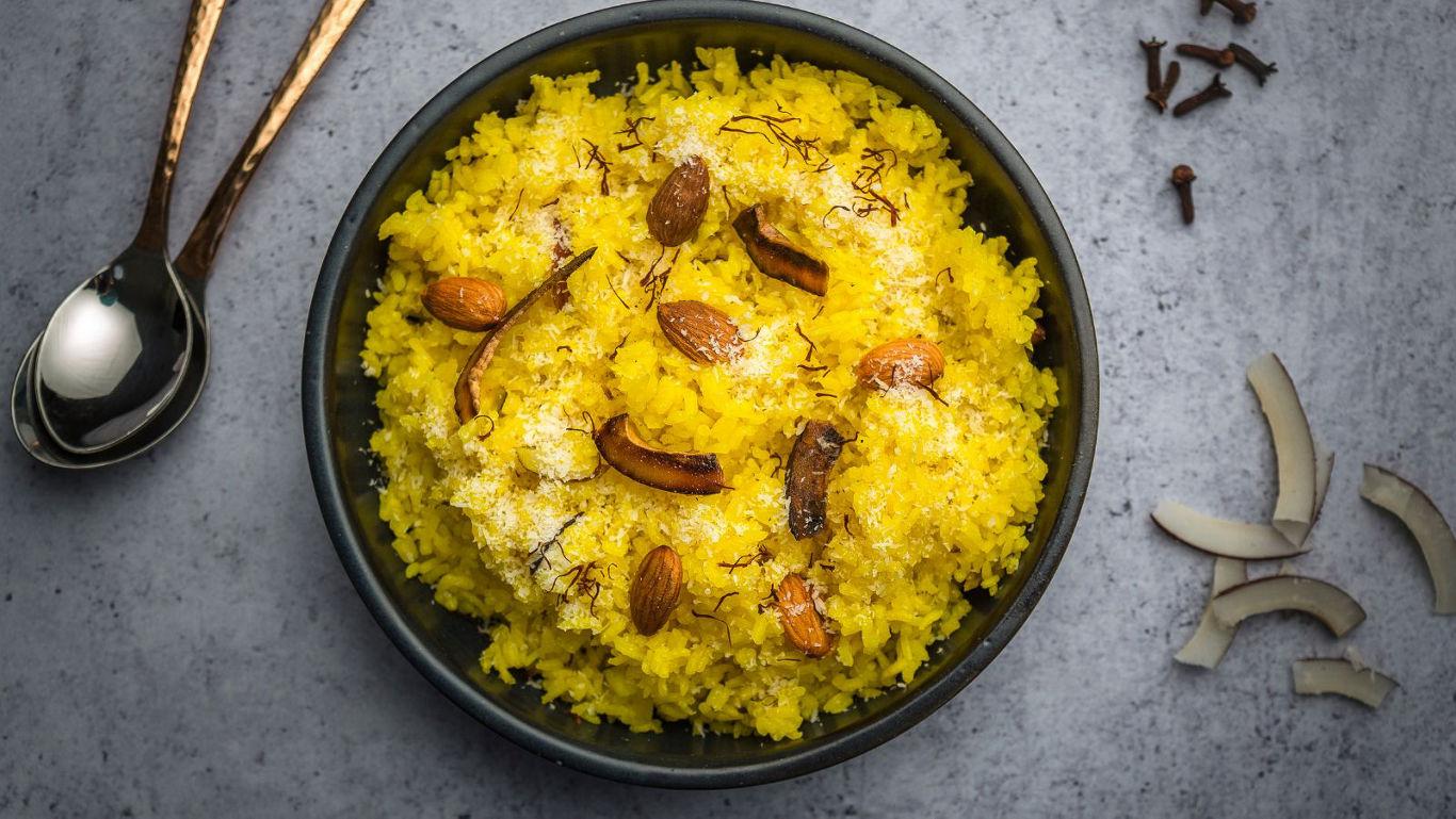 Saffron rice with nuts in black bowl