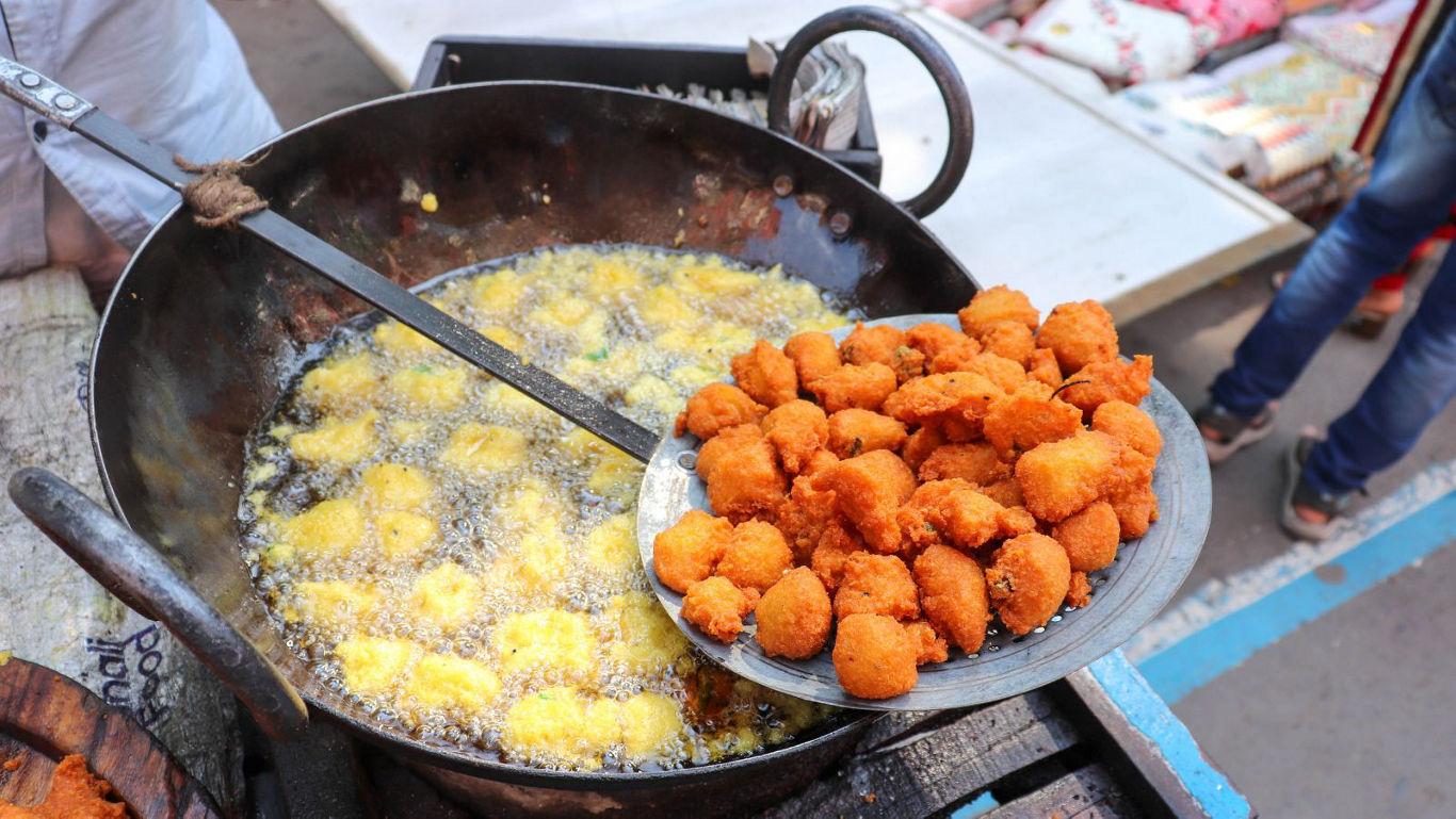 Street vendor frying crispy snacks outdoors