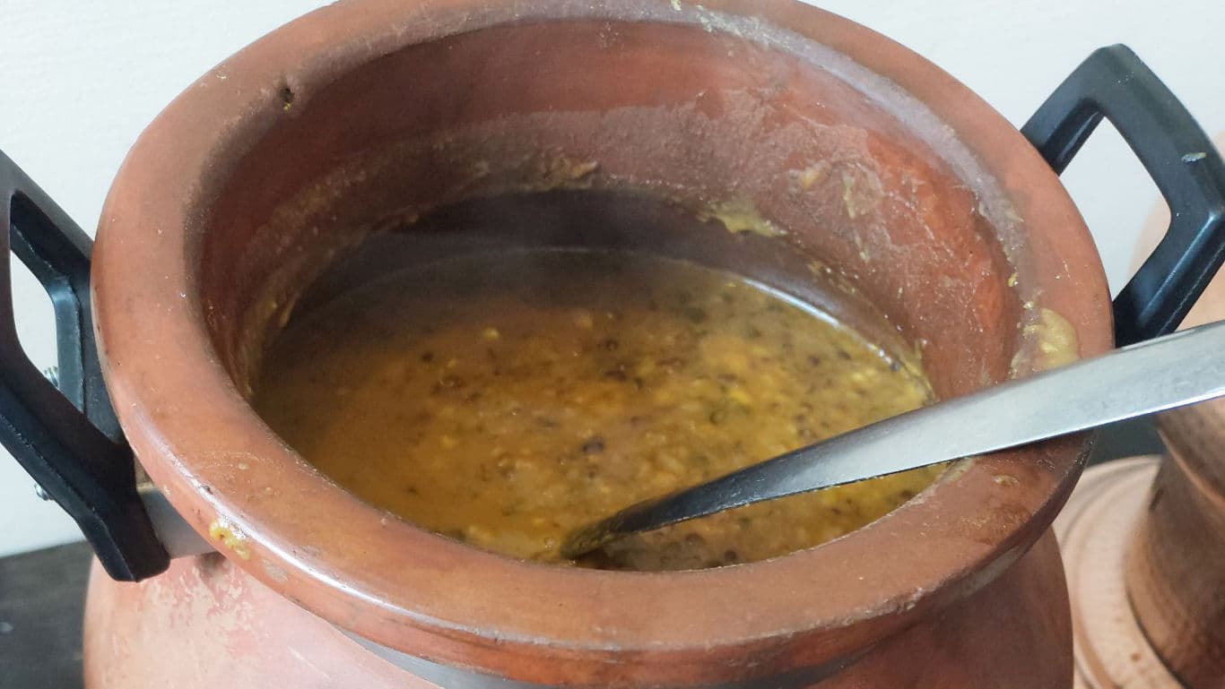 Traditional clay pot of simmering lentil curry
