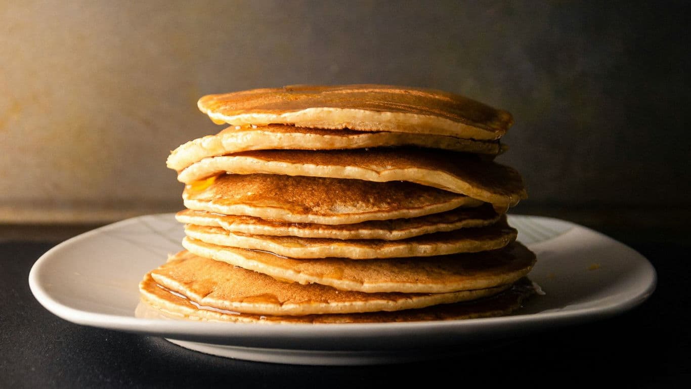 Stack of golden pancakes on plate