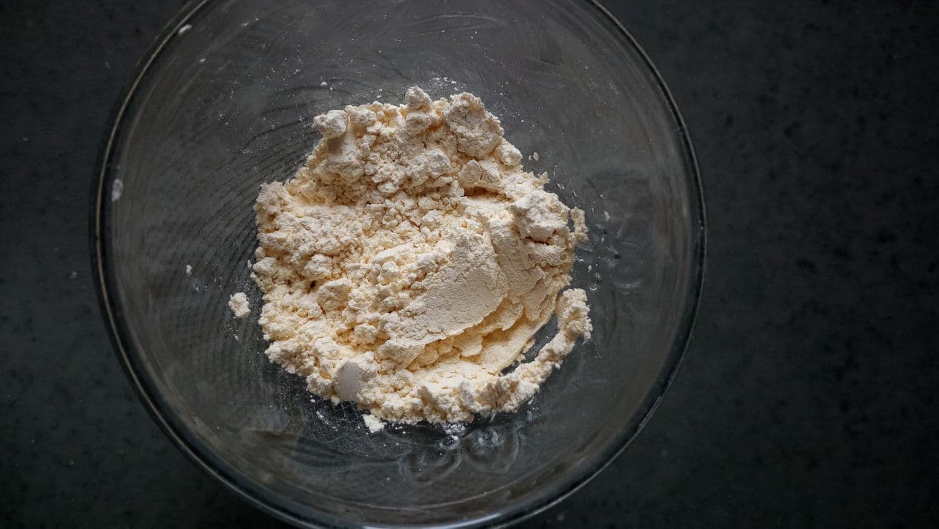 Bowl of flour mixture on dark countertop