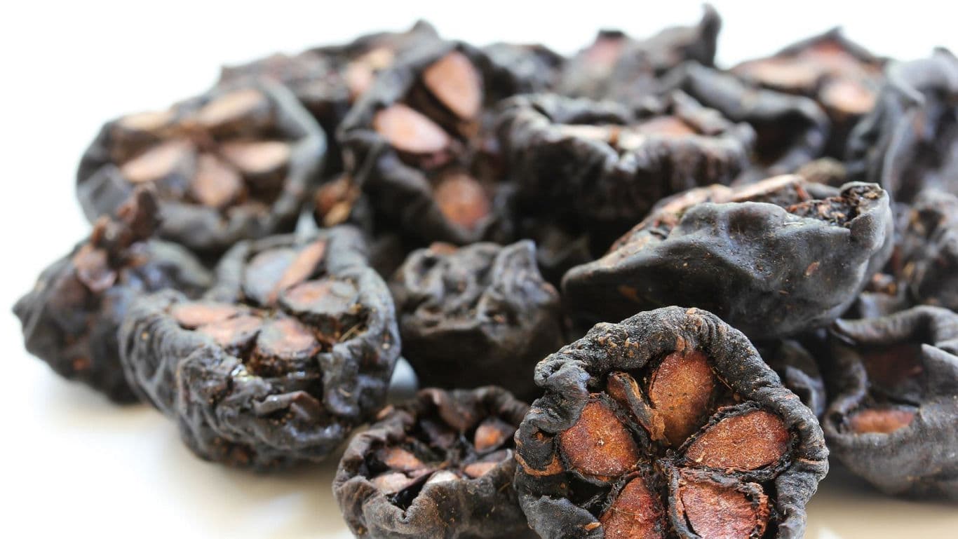 Close-up of dried black lime fruits on white background