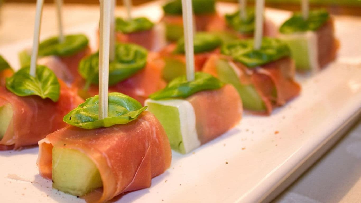 Prosciutto wrapped melon skewers with basil
