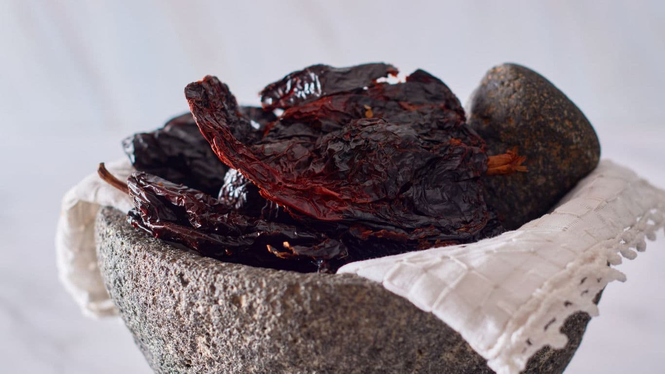 Dried red chiles in stone mortar
