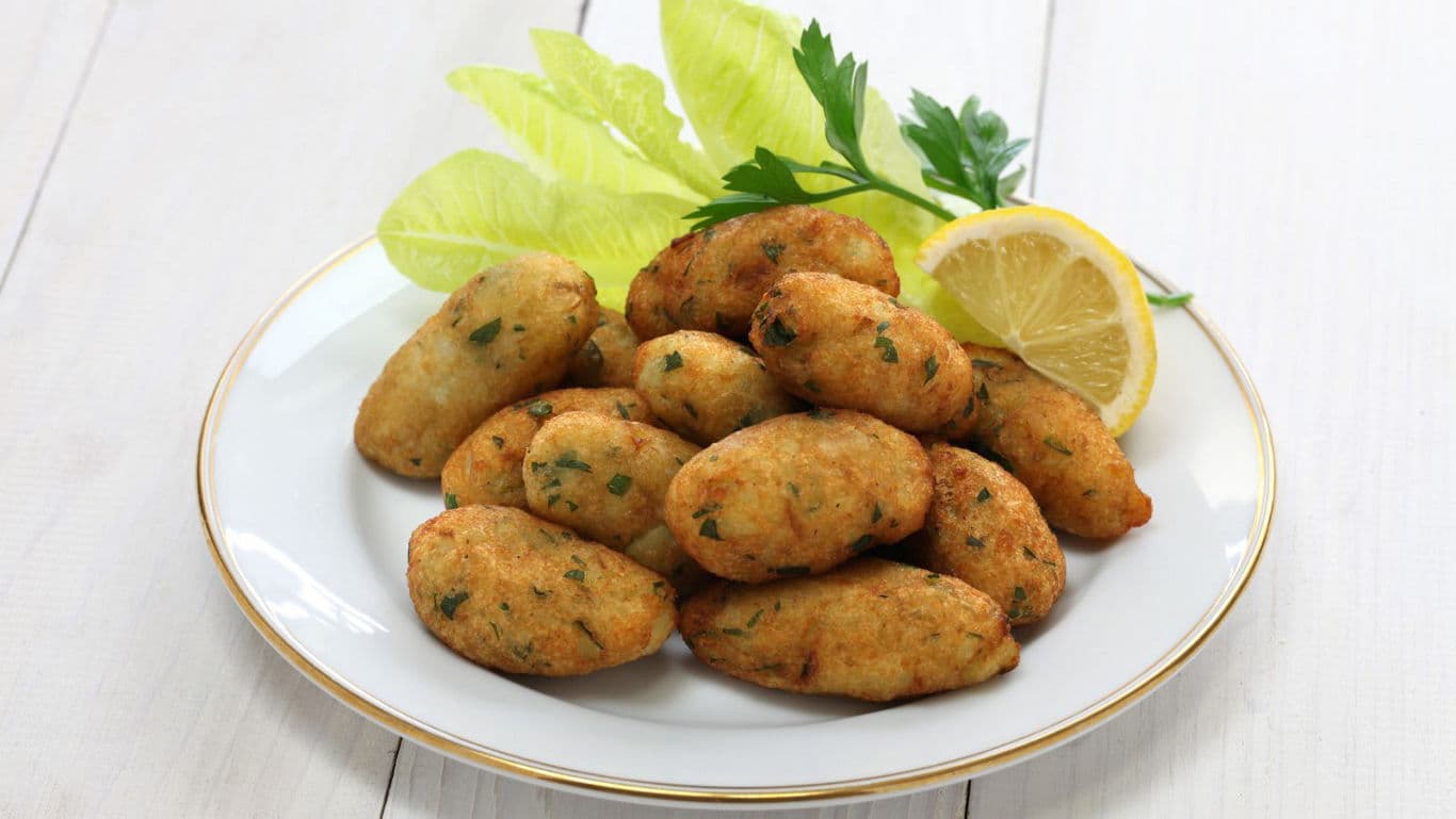 Plate of Golden Fried Croquettes with Lemon Garnish