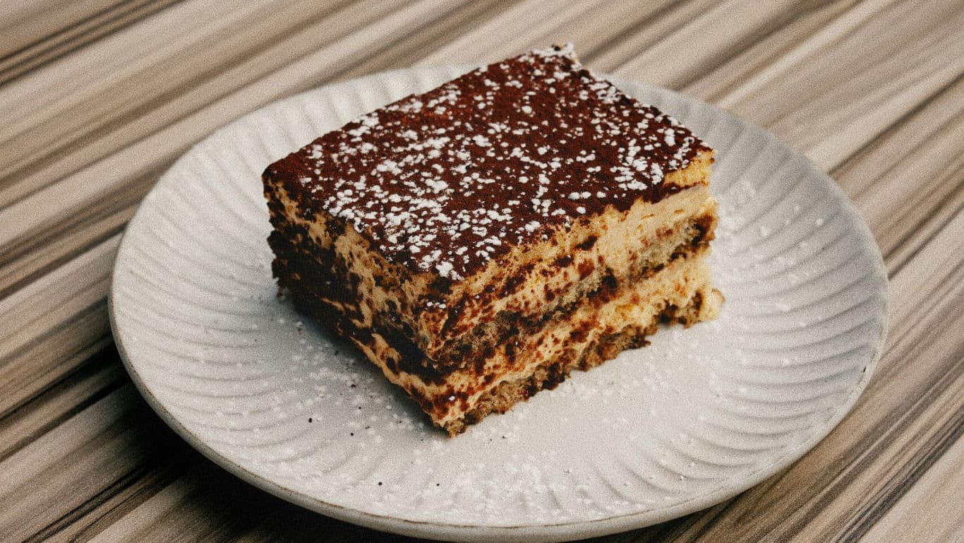 Slice of layered dessert with powdered sugar