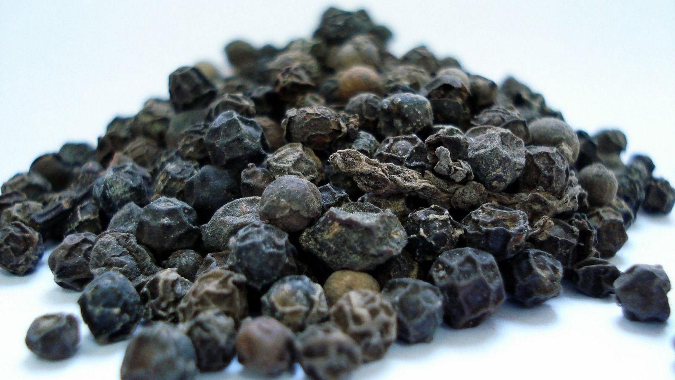 Close-up of black peppercorns on white background