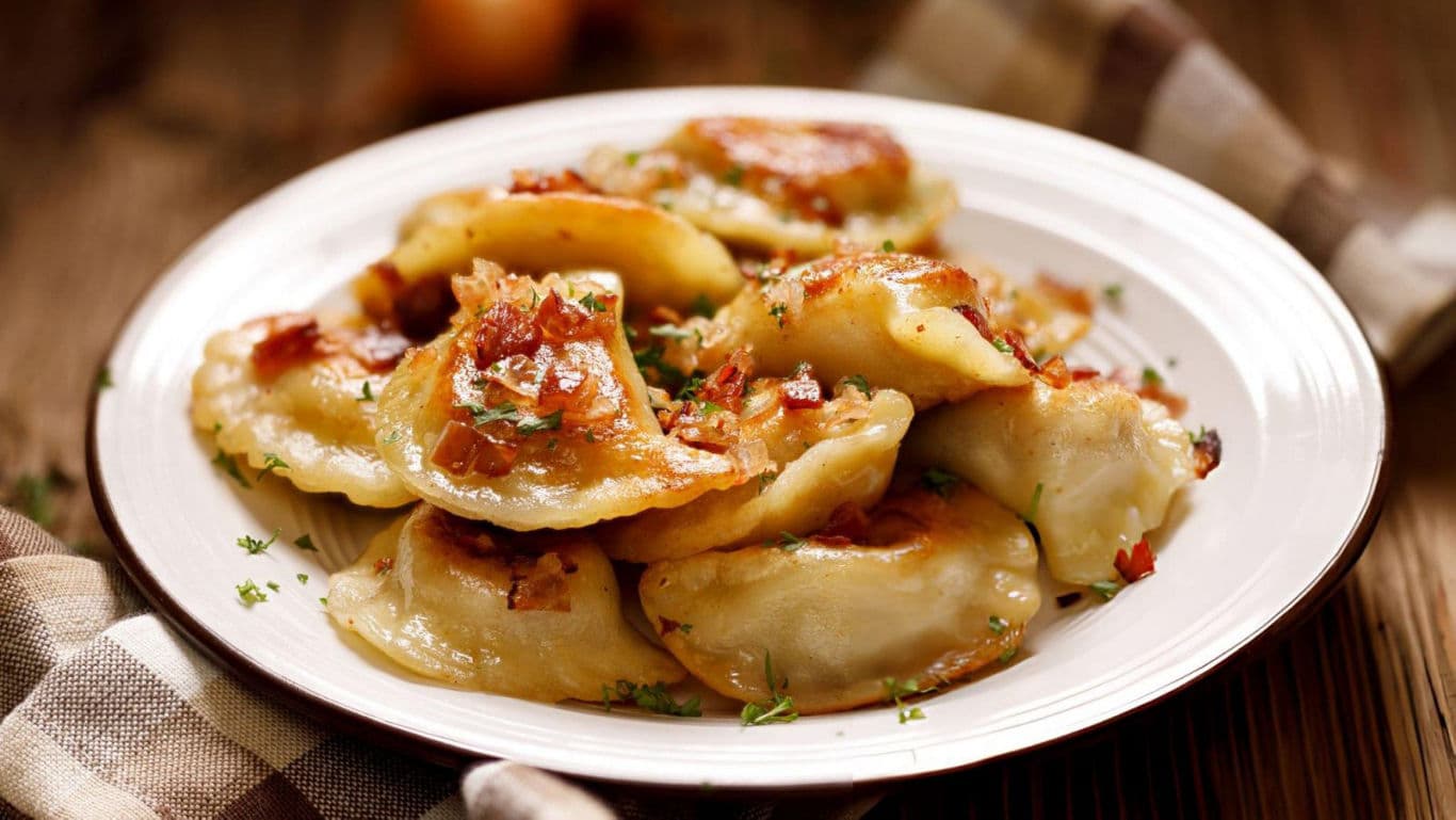 Plate of golden fried dumplings with herbs