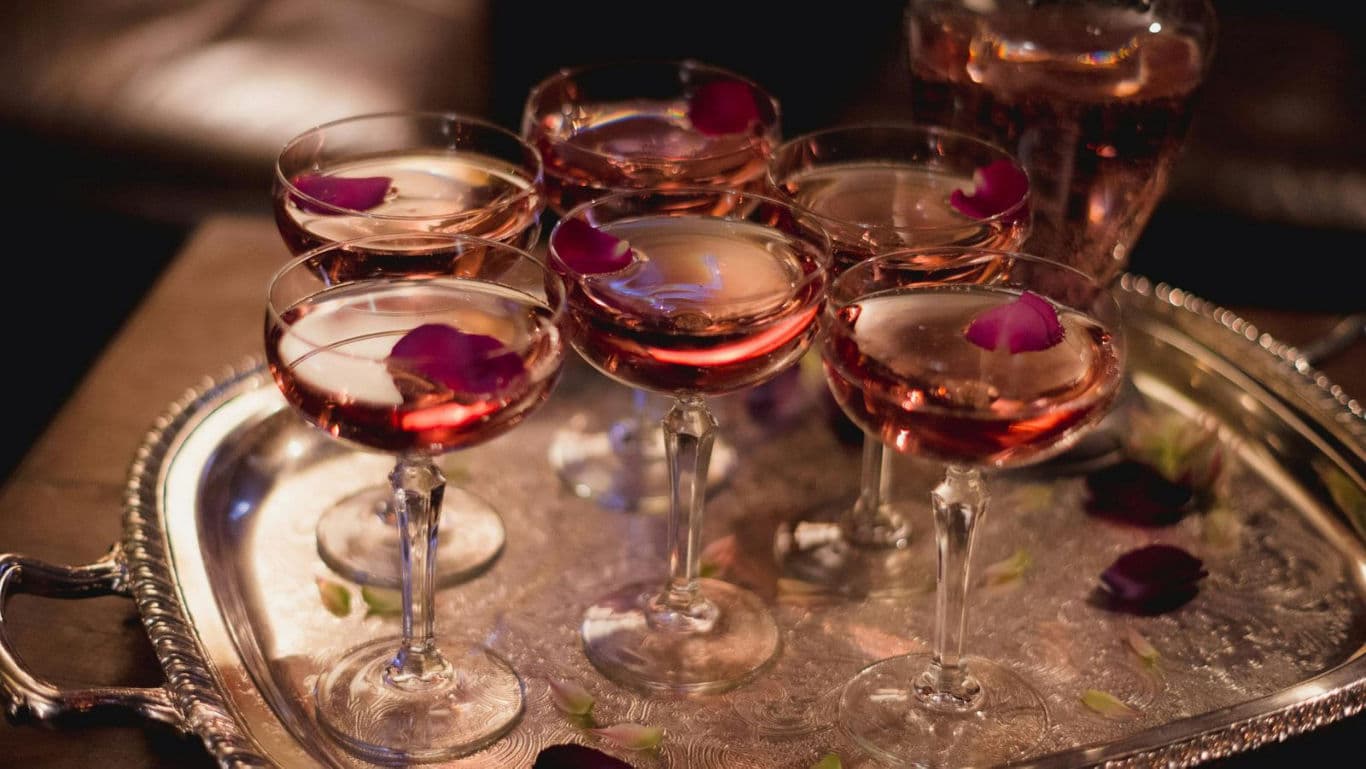 Elegant cocktail glasses with rose petals