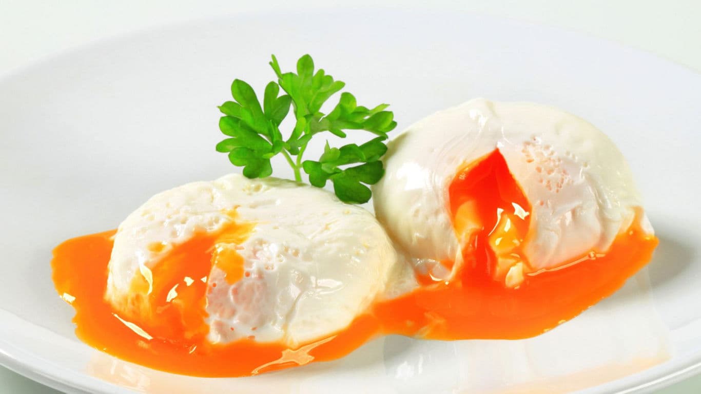 Soft poached eggs with fresh parsley garnish