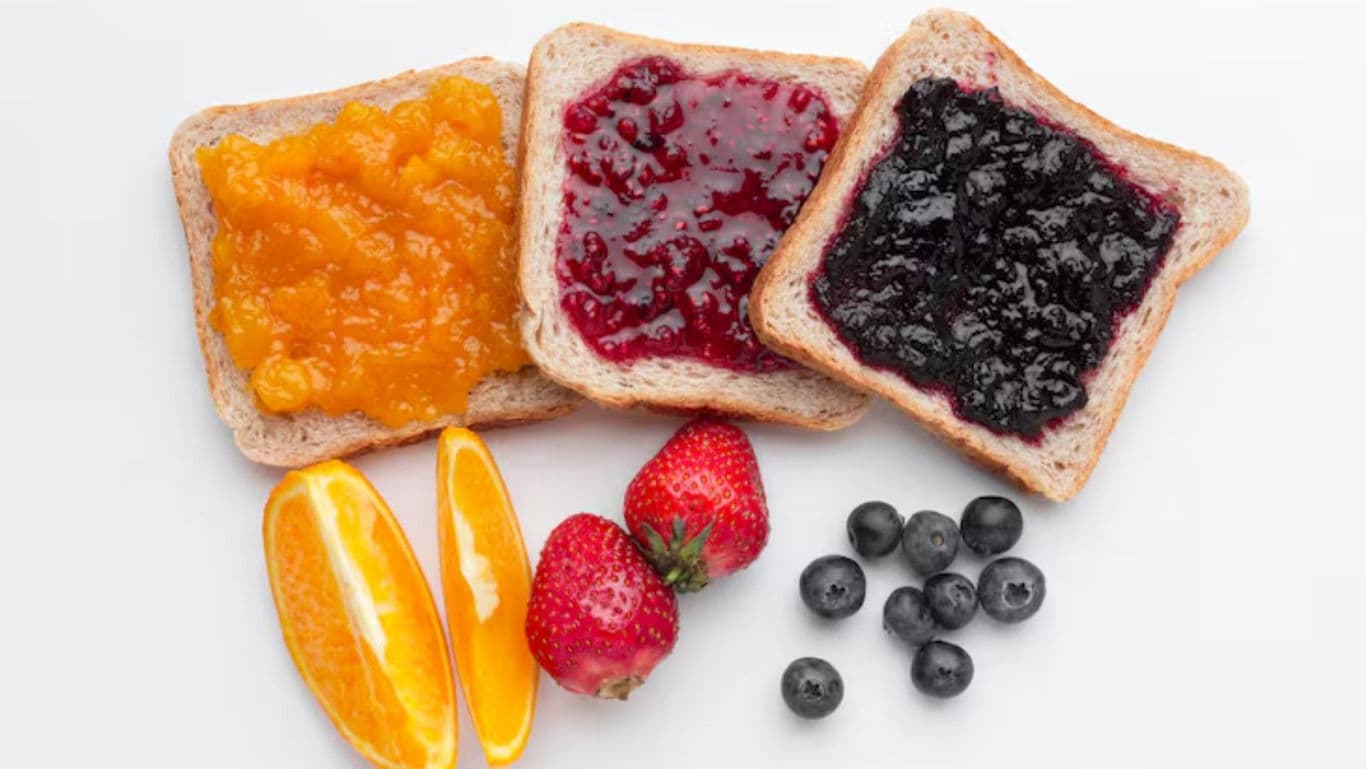 Three fruit jam toasts with fresh berries and orange slices