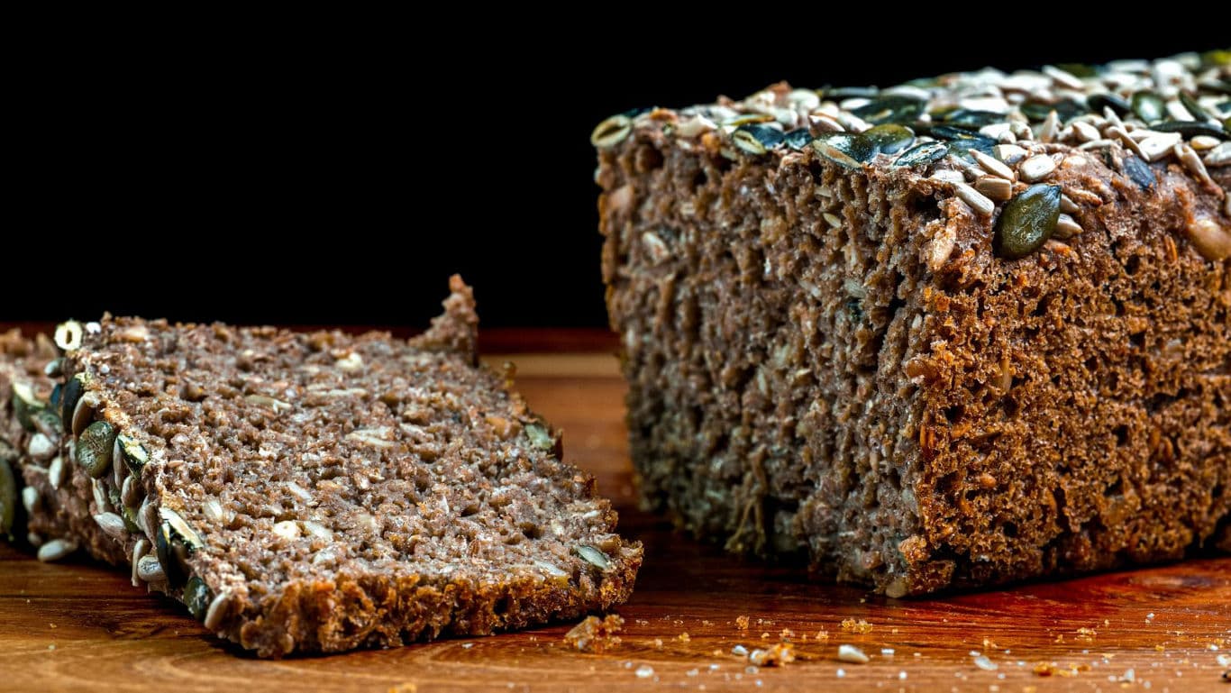 Sliced whole grain bread with seeds on board