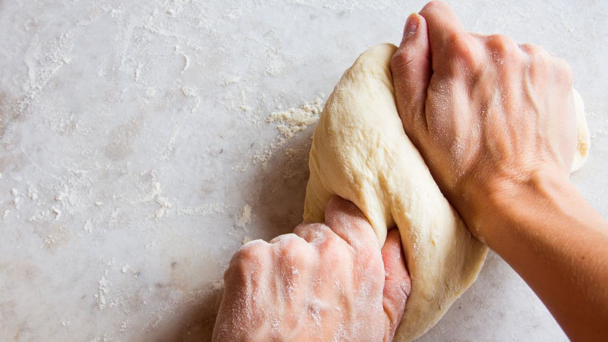 person kneading the dough